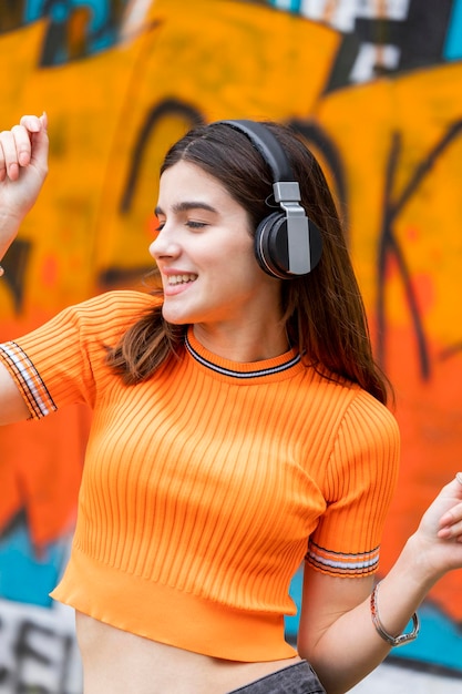 Portrait of young girl wearing headphones and dancing