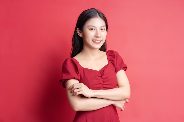 Portrait of young girl wearing red dress with expression on background