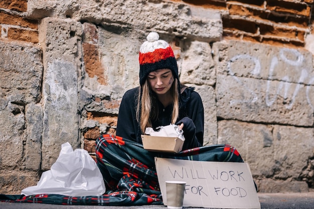 Portrait of a young girl with a dirty face in old dirty clothes