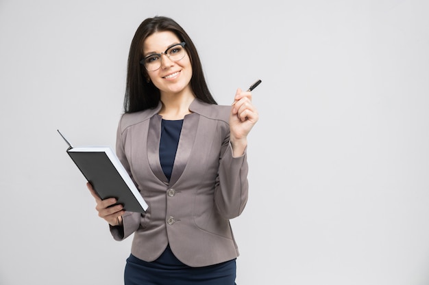 Portrait of a young girl with glasses with a diary in her hands isolated  a light  