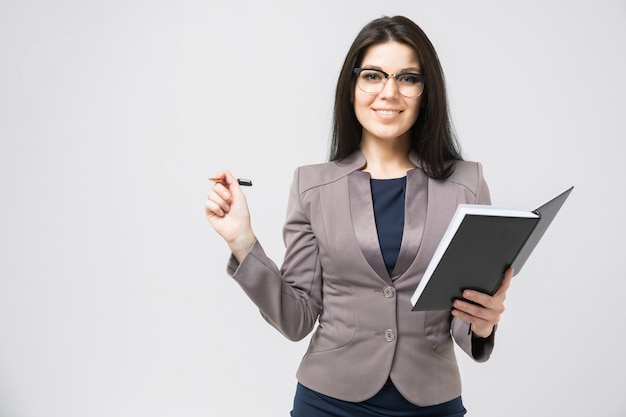 Portrait of a young girl with glasses with a diary in her hands isolated