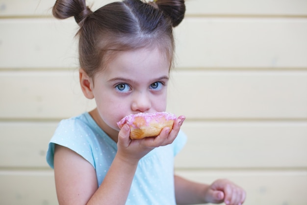 Foto ritratto di giovane ragazza con ciambella rosa