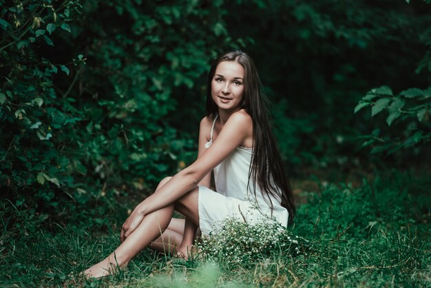 Foto ritratto di una giovane ragazza con fiori bianchi