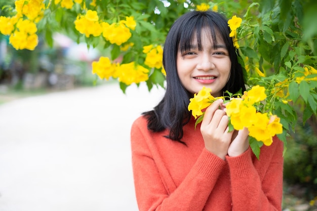 노란 꽃을 가진 세로 어린 소녀 아시아 소녀