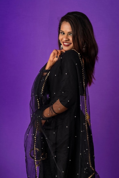 Portrait of a young girl or woman posing on purple background