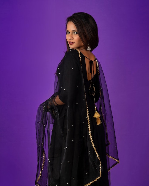 Portrait of a young girl or woman posing on purple background