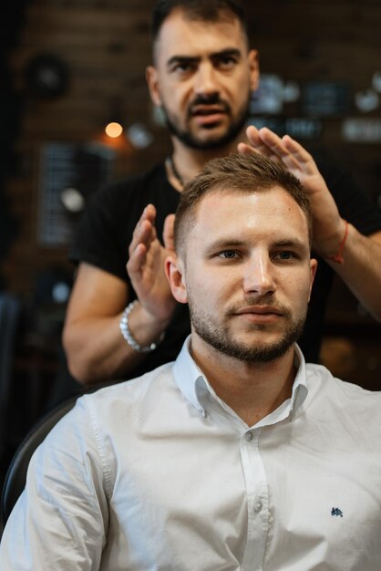 Photo portrait of a young guy groom at the training camp in the barbershop