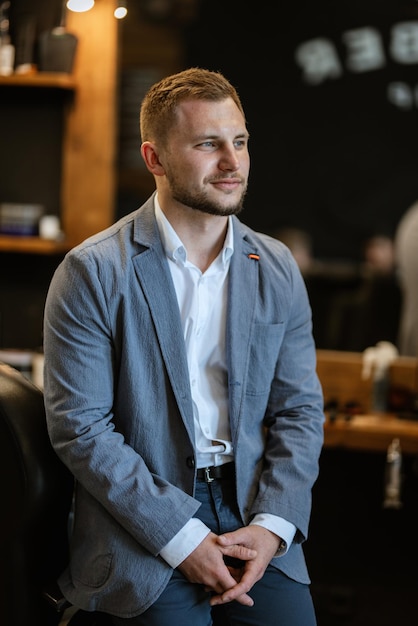 Photo portrait of a young guy groom at the training camp in the barbershop