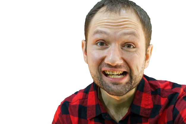 Portrait of a young guy in a red plaid shirt on a white background Stupid emotional face of a dirty man