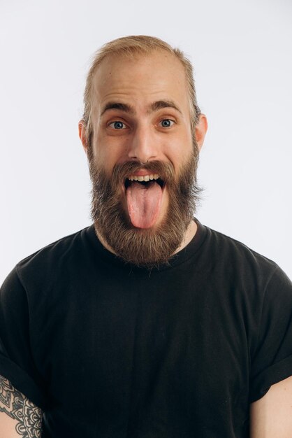 Photo portrait of a young guy with a beard in a black tshirt on a white background hipster