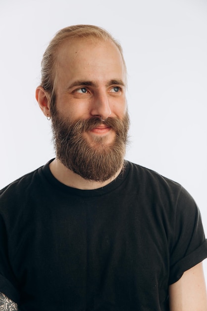 Portrait of a young guy with a beard in a black Tshirt on a white background hipster