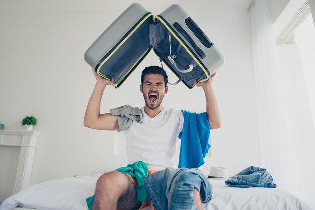 Portrait of young guy with a beard holding in the hotel room