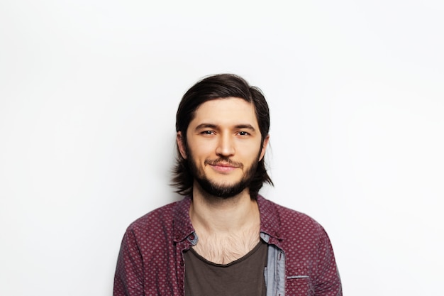 Portrait of young guy with long hair on white.