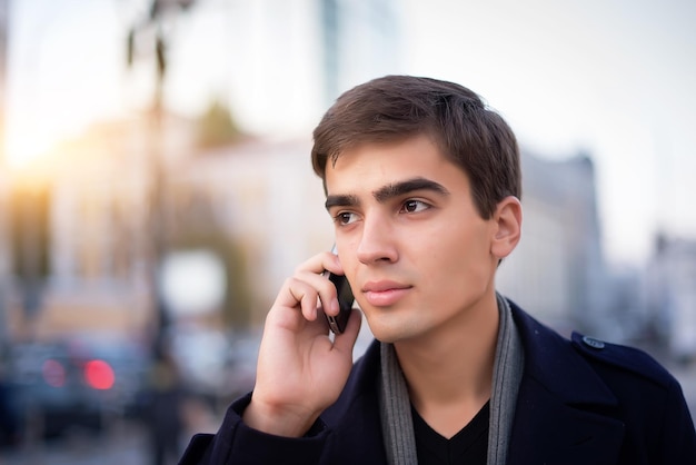 Portrait of a young guy with a phone in his hands.