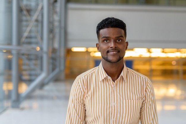 Portrait of young handsome African businessman wearing stylish clothes