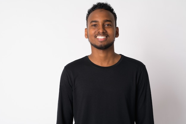 Portrait of young handsome African man against white wall