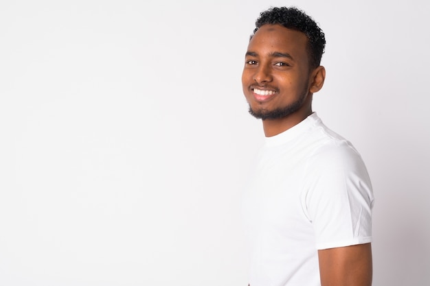 Portrait of young handsome African man against white wall