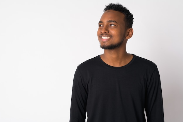 Portrait of young handsome African man against white wall