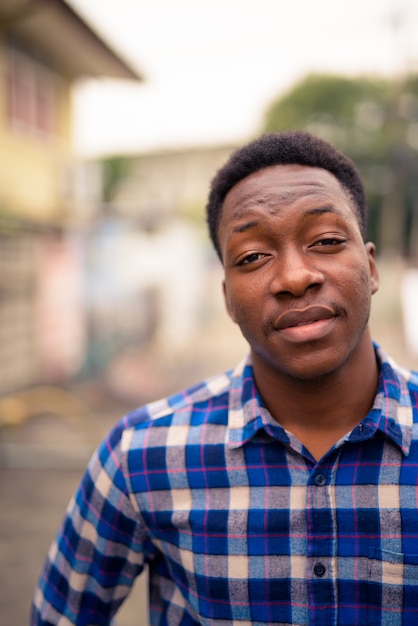 Portrait of young handsome African man in the streets outdoors