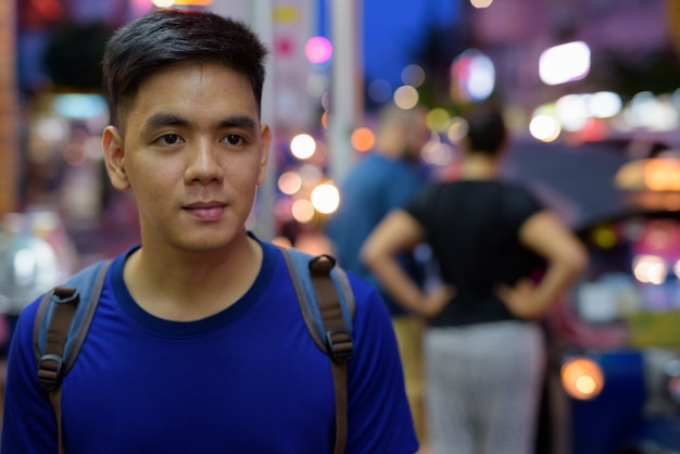 Portrait of young handsome Asian tourist man exploring at Chinatown in Bangkok, Thailand