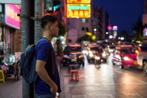 Portrait of young handsome Asian tourist man exploring at Chinatown in Bangkok, Thailand