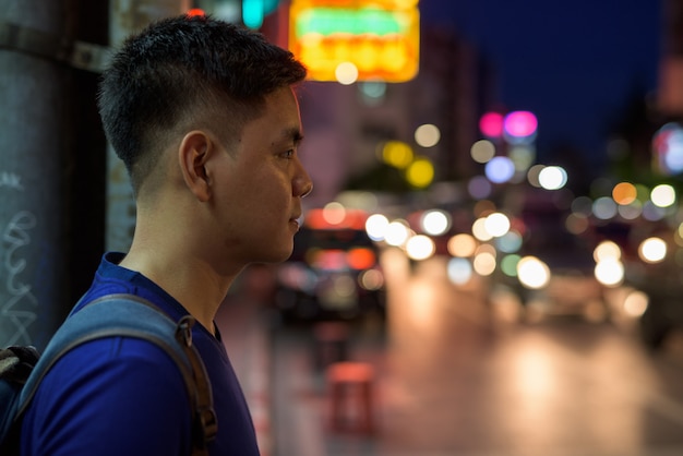 Portrait of young handsome Asian tourist man exploring at Chinatown in Bangkok, Thailand