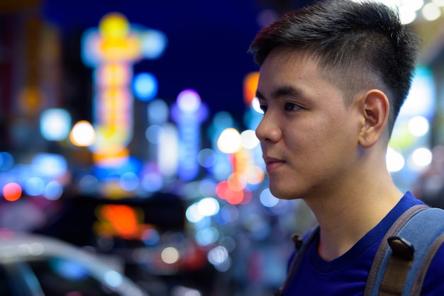 Portrait of young handsome Asian tourist man exploring at Chinatown in Bangkok, Thailand