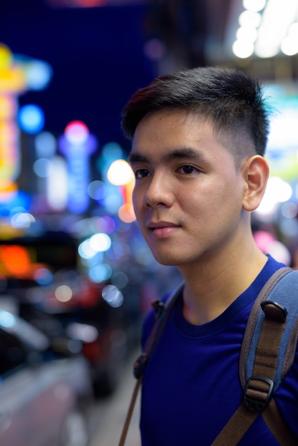 Portrait of young handsome Asian tourist man exploring at Chinatown in Bangkok, Thailand