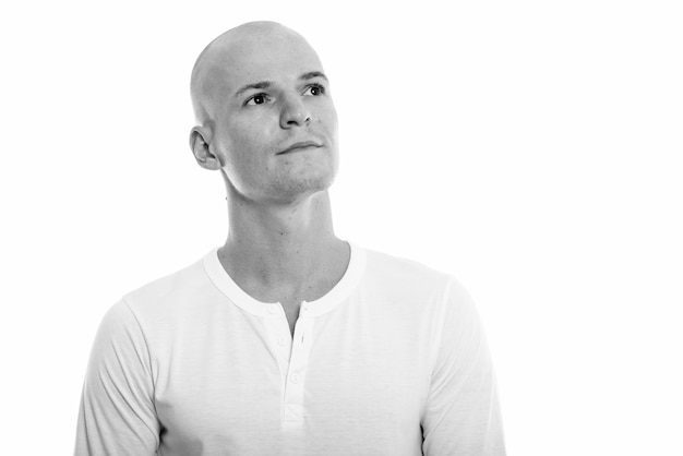 Portrait of young handsome bald man isolated on white in black and white