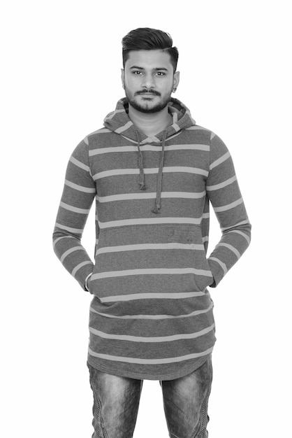 Portrait of young handsome bearded Indian man on white in black and white