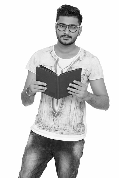 Portrait of young handsome bearded Indian man on white in black and white