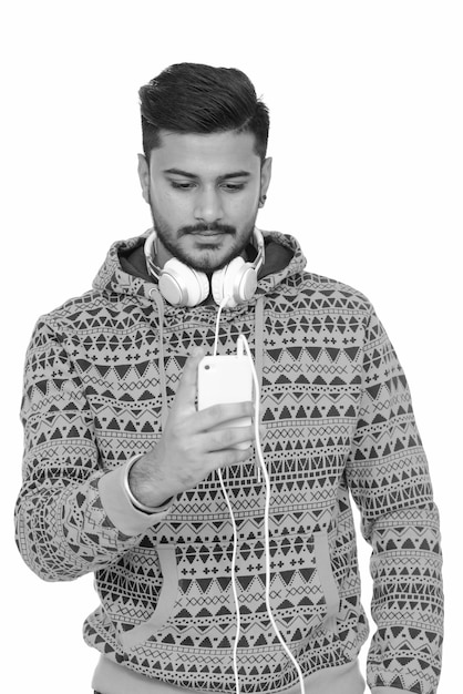 Portrait of young handsome bearded Indian man on white in black and white