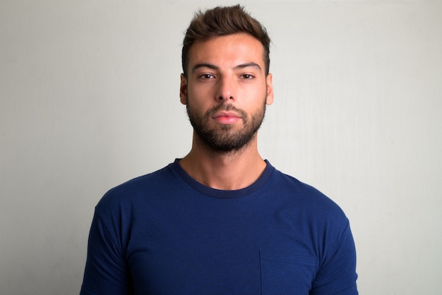 Photo portrait of young handsome bearded man on white