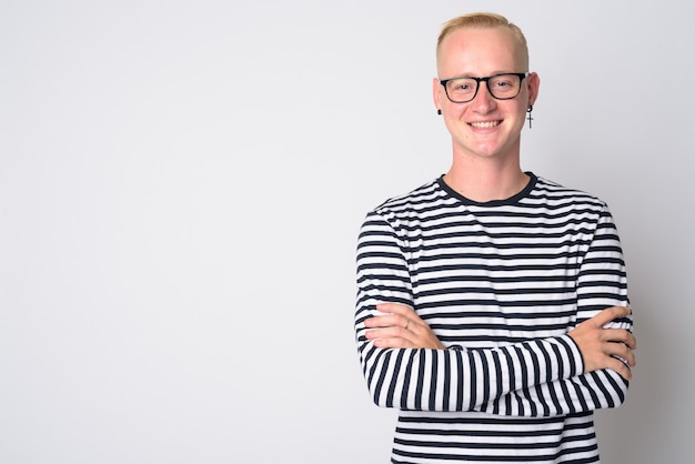 Portrait of young handsome blonde hipster man looking cool with monochrome clothing on white