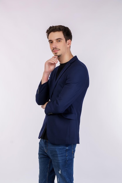 Photo portrait of young handsome businessman looking confident at the camera with smile with crossed arms and hand raised on chin over isolated background