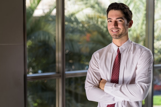 Portrait of young handsome businessman smiling in city