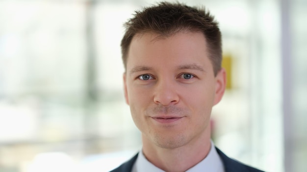 Portrait of young handsome businessman in suit in office