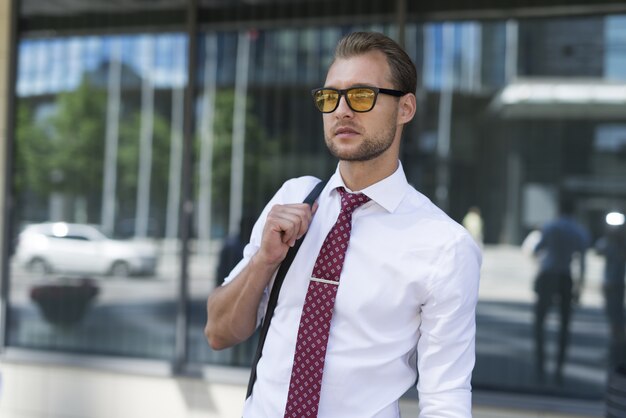 Portrait of a young handsome businessman walking in a city