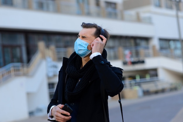 Ritratto di giovane uomo d'affari bello con maschera facciale in quarantena