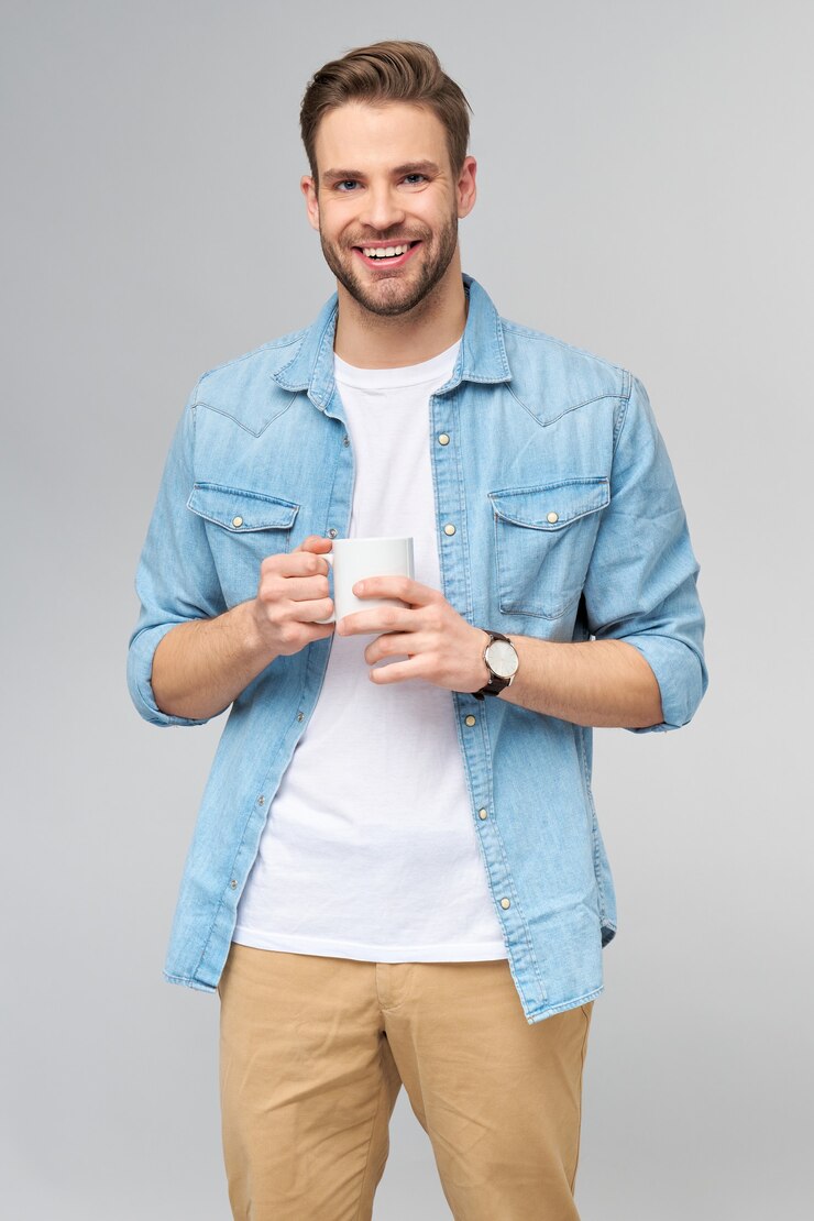 Photo portrait of young handsome caucasian man in jeans shirt holding cup of coffee