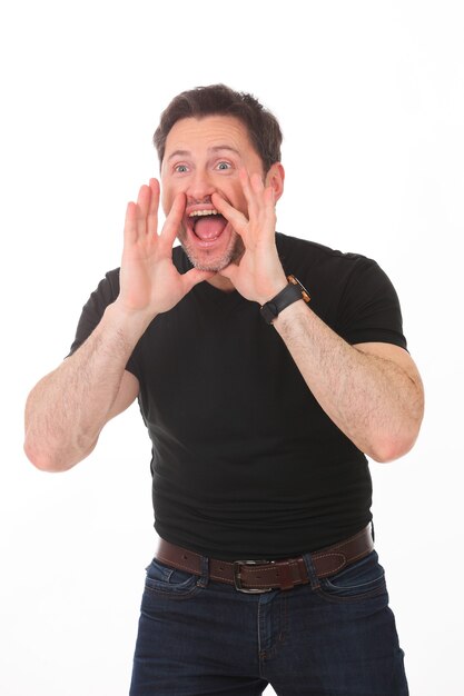 Portrait of young handsome charismatic man in black t-shirt screaming with hands up