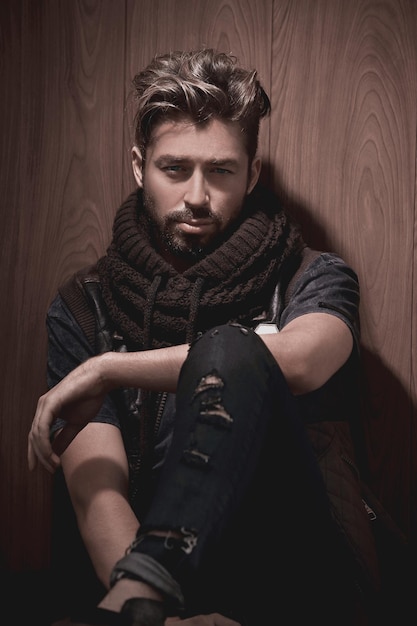 Portrait of young handsome fashionable man against wooden wall