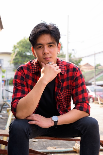 Photo portrait of young handsome filipino hipster man in the streets outdoors