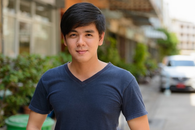 Portrait of young handsome Filipino man in the streets outdoors