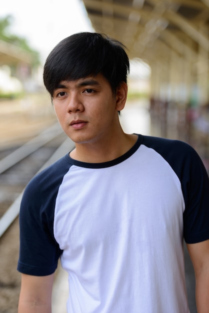 Portrait of young handsome Filipino tourist man at Hua Lamphong railway station in Bangkok