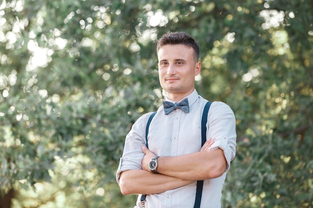 Portrait of a young handsome groom outdoors at sunset. fine art photography