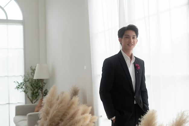 Portrait of young handsome groom in suit preparing for wedding ceremony