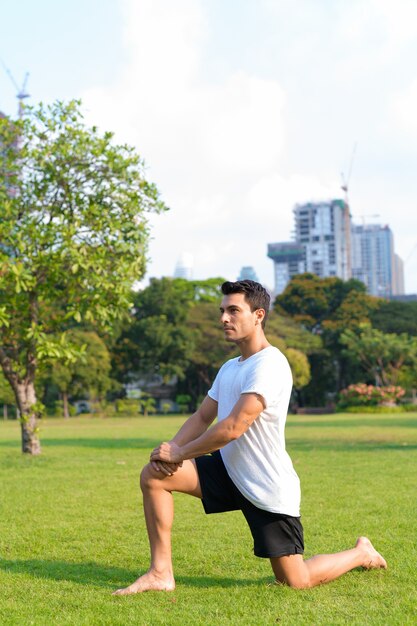 Portrait of young handsome Hispanic man in the park outdoors