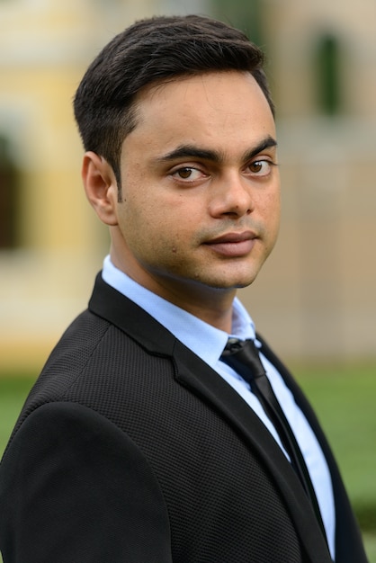 Photo portrait of young handsome indian businessman in the city