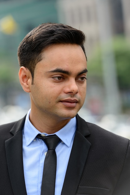 Portrait of young handsome Indian businessman in the city